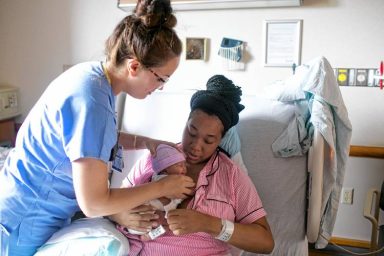 Nurse Jaclyn Noto, left, helps show Paivia Brown, right, how to hold her newborn daughter Paiton at Evanston Hospital on Monday, Sept. 10, 2018 in Evanston, Ill. (Kristen Norman/Chicago Tribune/TNS)